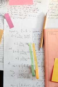 Detailed math notes with handwritten equations and colorful papers, perfect for educational use.